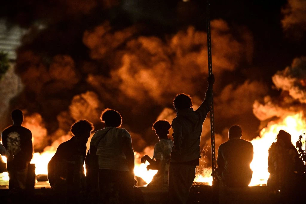 People look at burning tyres blocking a street in Bordeaux in south-western France on June 29, 2023, during riots and incidents nationwide after the killing of a 17-year-old boy by a police officer's gunshot following a refusal to comply in a western suburb of Paris.?w=200&h=150