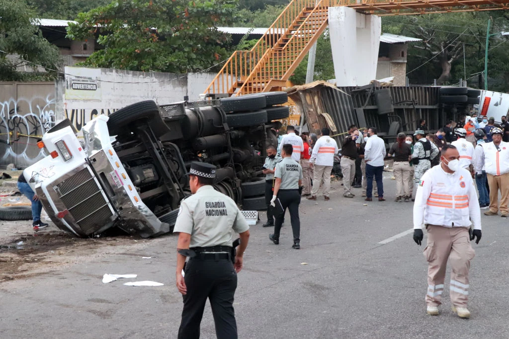 Mexican national guard officers work in the area where a trucked rolled over after a traffic accident that killed migrants from Central America, Dec. 9, 2021 in Tuxtla Gutierrez, Mexico. A truck accident leaves at least 49 people dead and dozens injured according to authorities. Most of the victims are believed to be migrants from Central American who were travelling on a truck that rolled over and crashed into a pedestrian bridge.?w=200&h=150