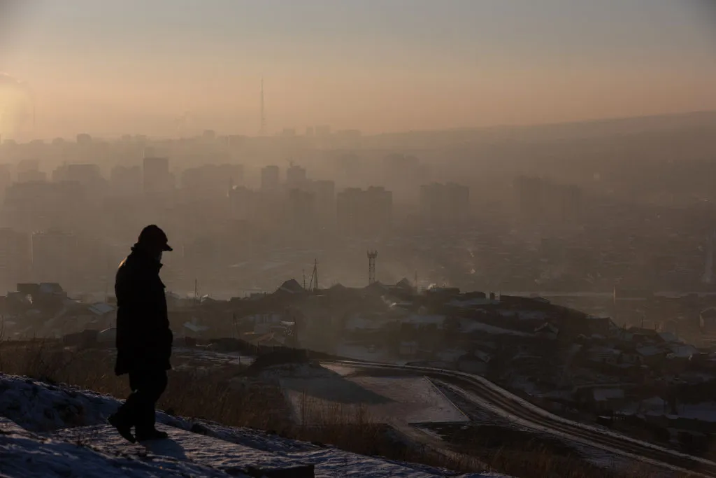This picture taken on Jan. 16, 2022, shows a man watching smoke hanging over houses on a polluted day in Ulaanbaatar, the capital of Mongolia.?w=200&h=150