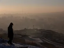 This picture taken on Jan. 16, 2022, shows a man watching smoke hanging over houses on a polluted day in Ulaanbaatar, the capital of Mongolia.