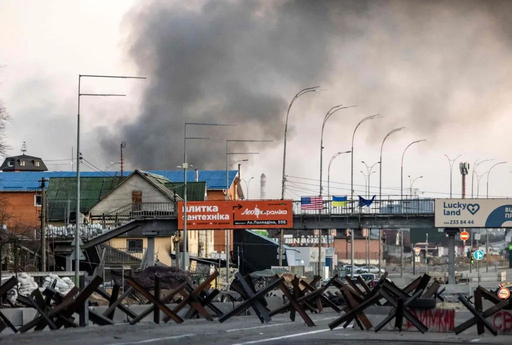 This photograph taken on March 18, 2022 shows smoke rising after an explosion in Kyiv. - Authorities in Kyiv said one person was killed early on March 18, 2022 when a downed Russian rocket struck a residential building in the capital's northern suburbs. They said a school and playground were also hit.?w=200&h=150