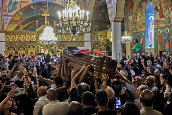 Palestinian mourners wave national flags as they carry the casket of slain Al-Jazeera journalist Shireen Abu Akleh inside the Melkite Greek Catholic Cathedral of Our Lady of the Annunciation, before her burial in Jerusalem, on May 13, 2022. - Abu Akleh, who was shot dead on May 11, 2022 while covering a raid in the Israeli-occupied West Bank, was among Arab media's most prominent figures and widely hailed for her bravery and professionalism. Ronaldo Schemidt/AFP via Getty Images