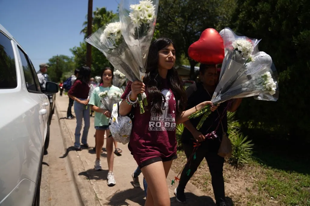 People arrive to drop off flowers at a makeshift memorial outside the Robb Elementary School on May 26, 2022 in Uvalde, Texas. - Grief at the massacre of 19 children at the elementary school in Texas spilled into confrontation on May 25, as angry questions mounted over gun control -- and whether this latest tragedy could have been prevented. The tight-knit Latino community of Uvalde on May 24 became the site of the worst school shooting in a decade, committed by a disturbed 18-year-old armed with a legally bought assault rifle.?w=200&h=150