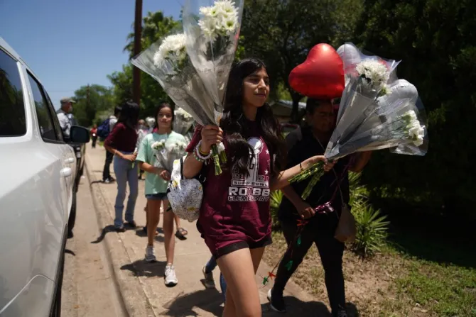 People arrive to drop off flowers at a makeshift memorial outside the Robb Elementary School on May 26, 2022 in Uvalde, Texas.
