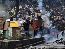 Demonstrators clash with riot police, nearby El Ejido park, in Quito, on June 24, 2022, in the framework of indigenous-led protests against the government. - Ecuador's government and Indigenous protesters accused each other of intransigence as thousands gathered for a 12th day of a fuel price revolt that has claimed six lives and injured dozens. After the most violent day of the campaign so far -- with police firing tear gas to disperse thousands storming Congress -- the government accused protesters of shunning a peaceful outcome.