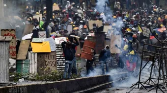 Demonstrators clash with riot police, nearby El Ejido park, in Quito, on June 24, 2022, in the framework of indigenous-led protests against the government. - Ecuador's government and Indigenous protesters accused each other of intransigence as thousands gathered for a 12th day of a fuel price revolt that has claimed six lives and injured dozens. After the most violent day of the campaign so far -- with police firing tear gas to disperse thousands storming Congress -- the government accused protesters of shunning a peaceful outcome.