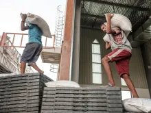 Workers carry sacks of grain in a warehouse of the World Food Programme (WFP) in the city of Abala, Ethiopia, on June 9, 2022. The Afar region was the only passageway for humanitarian convoys bound for Tigray.