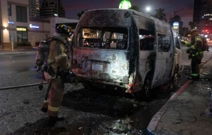 Firefighters work at the scene of a burnt collective transport vehicle after it was set on fire by unidentified individuals in Tijuana, Baja California state, Mexico, on Aug. 12, 2022. Photo by GUILLERMO ARIAS/AFP via Getty Images