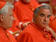 Italian Cardinal Giovanni Angelo Becciu (right) waits prior to the start of a consistory during which 20 new cardinals are to be created by the Pope, on Aug. 27, 2022 at St. Peter's Basilica in the Vatican. (