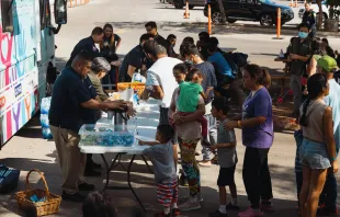 Groups of migrants wait outside the Migrant Resource Center to receive food from San Antonio Catholic Charities on Sept. 19, 2022, in San Antonio, Texas. Credit: Jordan Vonderhaar/Getty Images