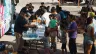 Groups of migrants wait outside the Migrant Resource Center to receive food from San Antonio Catholic Charities on Sept. 19, 2022, in San Antonio, Texas.