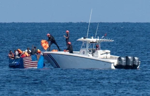 Members of the Cuban Coast Guard hand out life jackets to migrants on a drifting boat in Havana on Dec. 12, 2022. Photo by YAMIL LAGE/AFP via Getty Images