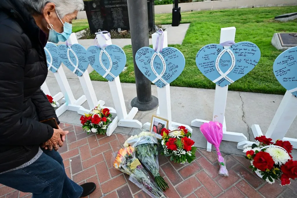 A woman takes a closer look at the names of 11 people killed in a mass shooting written on crosses and displayed during a candlelight vigil in front of the City Hall in Monterey Park, California, on Jan. 24, 2023.?w=200&h=150