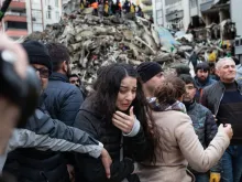 A woman reacts as rescuers search for survivors through the rubble of collapsed buildings in Adana, Turkey, on Feb. 6, 2023, after a 7.8-magnitude earthquake struck the country’s southeast. The combined death toll for Turkey and Syria after the region’s strongest quake in nearly a century is in the thousands.