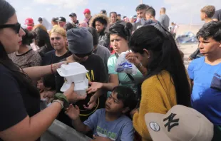 Venezuelan migrants receive food while waiting for information to enter Peru in Arica, at the Chile-Peru border, on May 4, 2023. Credit: AGUSTIN MERCADO/AFP via Getty Images