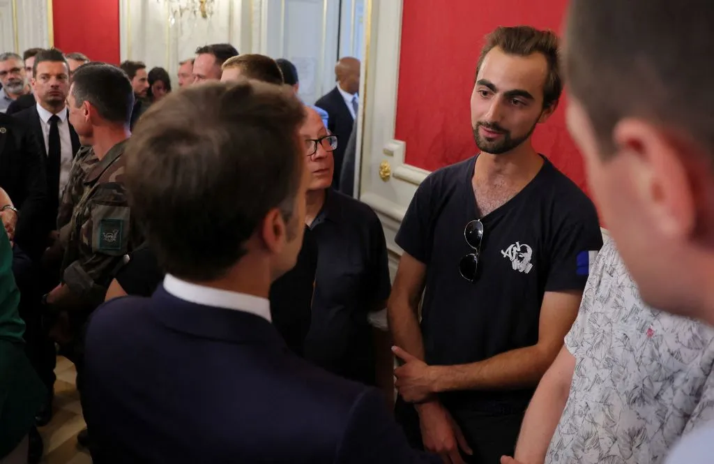 French President Emmanuel Macron (left) talks with Henri (right), the 24-year-old known as the "backpack hero," during a meeting with rescue forces at the Haute-Savoie prefecture a day after a mass stabbing in a park in Annecy in the French Alps on June 9, 2023.?w=200&h=150