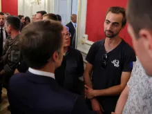 French President Emmanuel Macron (left) talks with Henri (right), the 24-year-old known as the "backpack hero," during a meeting with rescue forces at the Haute-Savoie prefecture a day after a mass stabbing in a park in Annecy in the French Alps on June 9, 2023.