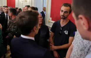 French President Emmanuel Macron (left) talks with Henri (right), the 24-year-old known as the "backpack hero," during a meeting with rescue forces at the Haute-Savoie prefecture a day after a mass stabbing in a park in Annecy in the French Alps on June 9, 2023. Credit: Photo by DENIS BALIBOUSE/POOL/AFP via Getty Images
