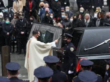 A priest sprinkles holy water on the casket of fallen NYPD Officer Jason Rivera during his funeral at St. Patrick's Cathedral, Jan. 28, 2022 in New York City. The 22-year-old NYPD officer was shot and killed on January 21 in Harlem while responding to a domestic disturbance call. Rivera's partner, Officer Wilbert Mora, also died from injuries suffered in the shooting.