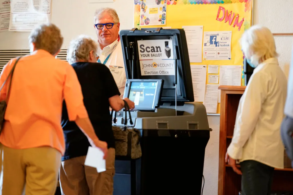 A poll worker helps a voter cast their ballot in the Kansas Primary Election at Merriam Christian Church on August 02, 2022 in Merriam, Kansas.?w=200&h=150