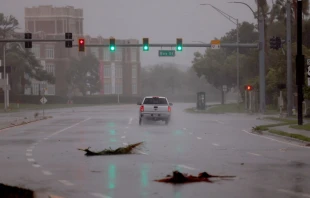 A vehicle drives through the winds and rain from Hurricane Ian on Sept. 28, 2022, in Sarasota, Florida. Ian is hitting the area as a likely Category 4 hurricane. Photo by Joe Raedle/Getty Images