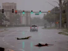 A vehicle drives through the winds and rain from Hurricane Ian on Sept. 28, 2022, in Sarasota, Florida. Ian is hitting the area as a likely Category 4 hurricane.