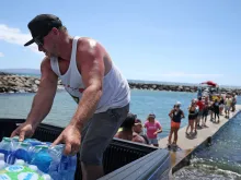 Volunteers load water onto a boat to be transported to West Maui from the Kihei boat landing on Aug. 13, 2023 in Kihei, Hawaii.