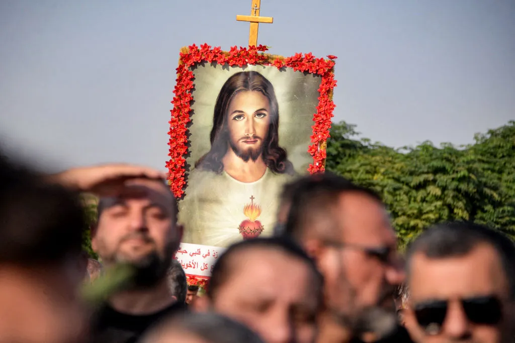 A mourner holds up an image of the Sacred Heart of Jesus at the funeral on Sept. 27, 2023, of victims who were killed when a fire ripped through a crowded wedding hall in the mainly Christian northern city of Qaraqosh, Iraq, also known as Hamdaniyah. At least 100 people were killed, officials said, pointing to indoor fireworks as the likely cause for the blaze that sparked a panicked stampede for the exits.?w=200&h=150