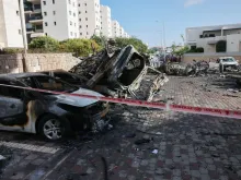 A picture taken in the southern Israeli city of Ashkelon on Oct. 7, 2023, shows burnt-out vehicles outside a residential building hit in a rocket attack from the Gaza Strip.