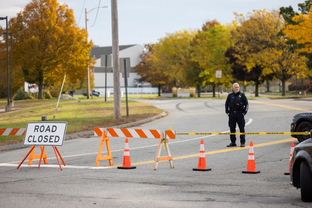A police officer blocks access to the road to Sparetime Recreation on Oct. 26, 2023, in Lewiston, Maine. Police are still searching for the suspect in the mass shooting, Robert Card.?w=200&h=150