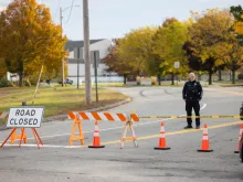 A police officer blocks access to the road to Sparetime Recreation on Oct. 26, 2023, in Lewiston, Maine. Police are still searching for the suspect in the mass shooting, Robert Card.