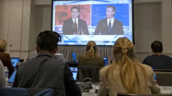 Florida governor and Republican presidential hopeful Ron DeSantis (left) and California Gov. Gavin Newsom appear on screen from the press room during a debate held by Fox News in Alpharetta, Georgia, on Nov. 30, 2023.