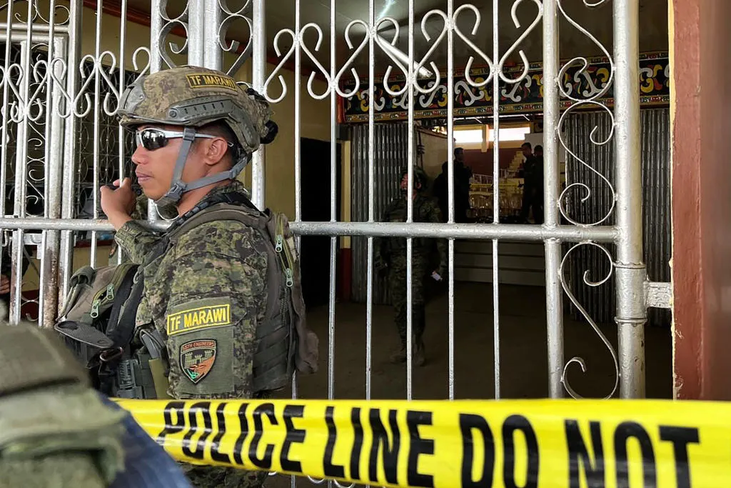 Military personnel stand guard at the entrance of a gymnasium while police investigators look for evidence after a bomb attack at a Catholic Mass at Mindanao State University in Marawi, Lanao del sur province in the southern Philippines on Dec. 3, 2023. At least three people were killed and seven wounded, officials said.?w=200&h=150