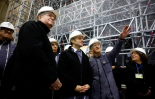 French President Emmanuel Macron, flanked by president of the public establishment "Rebuilding Notre-Dame de Paris" Philippe Jost (right) and and Archbishop of Paris Laurent Ulrich (left), visits the nave of the Notre-Dame de Paris Cathedral during its reconstruction on Dec. 8, 2023. Credit: SARAH MEYSSONNIER/POOL/AFP via Getty Images