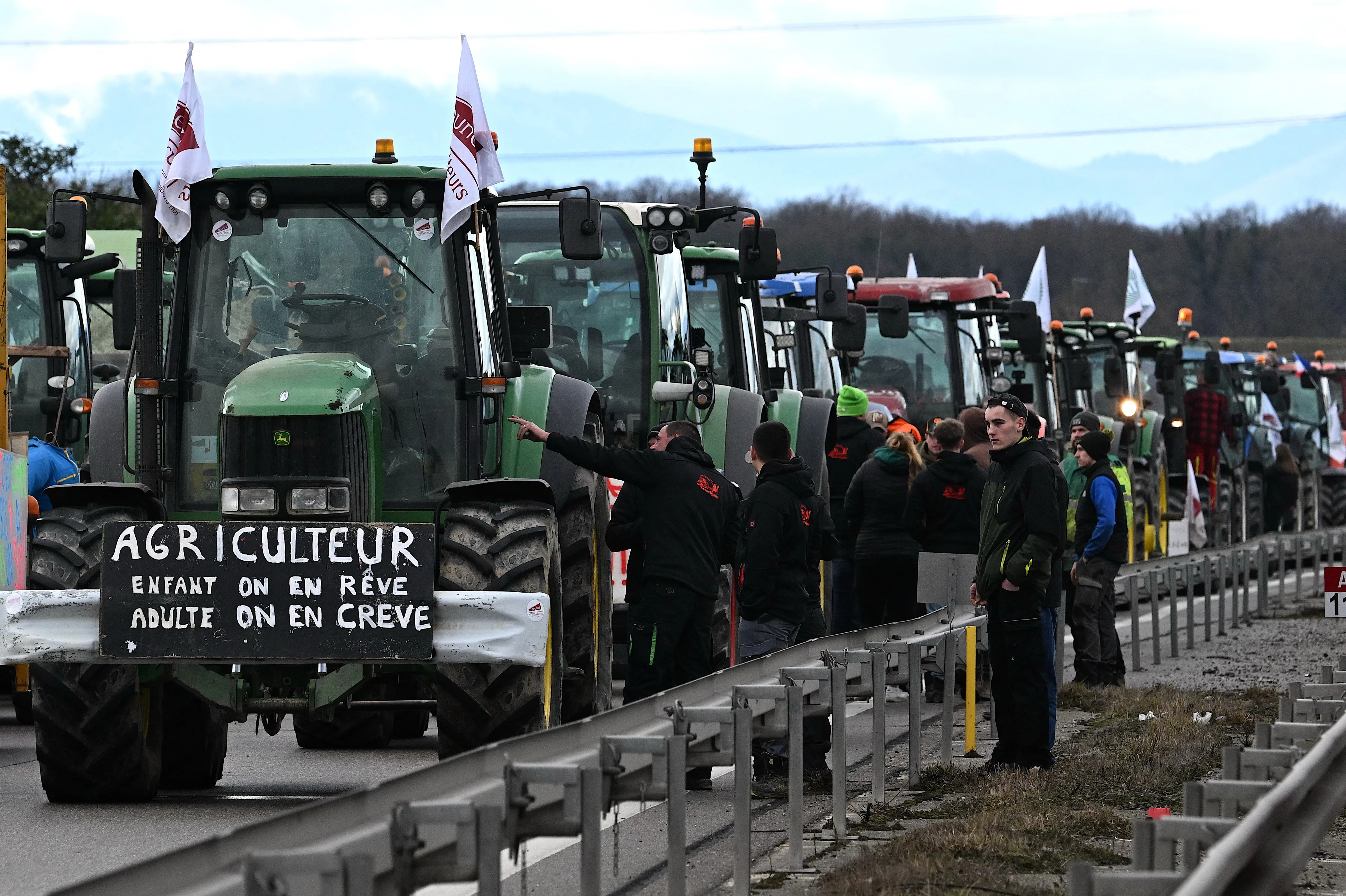 French farmers stand next to their tractors as they block the road during a demonstration at the French-German border in Ottmarsheim, eastern France, on Feb. 1, 2024, as part of nationwide protests called by several farmers’ unions over pay, tax, and regulations.?w=200&h=150