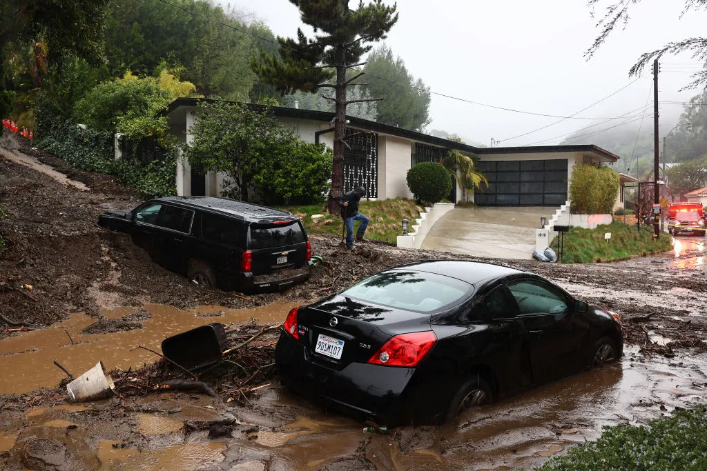 A person attempts to clear away debris from a mudslide as a powerful long-duration atmospheric river storm, the second in less than a week, continues to impact Southern California on Feb. 5, 2024, in Beverly Hills, California.?w=200&h=150