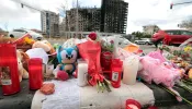 This photograph shows flowers and candles laid out on the sidewalk after a huge fire killed ten people in a multi-story residential block, in Valencia on February 26, 2024. Ten people have died in a vast fire that ripped through a 14-story apartment block in Valencia in eastern Spain.