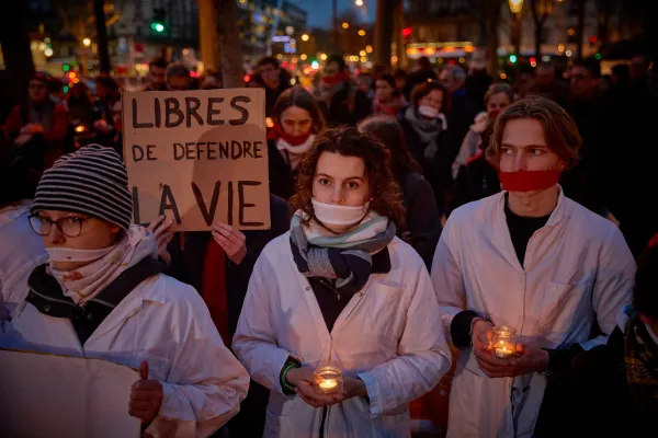 Protestors with cloths covering their mouths, hold candles and a slogan which reads " Free to defend life" during a silent pro-life demonstration in Paris, on February 28, 2024 as the Senate started debates for inclusion of abortion in the constitution. Credit: Photo by KIRAN RIDLEY/AFP via Getty Images