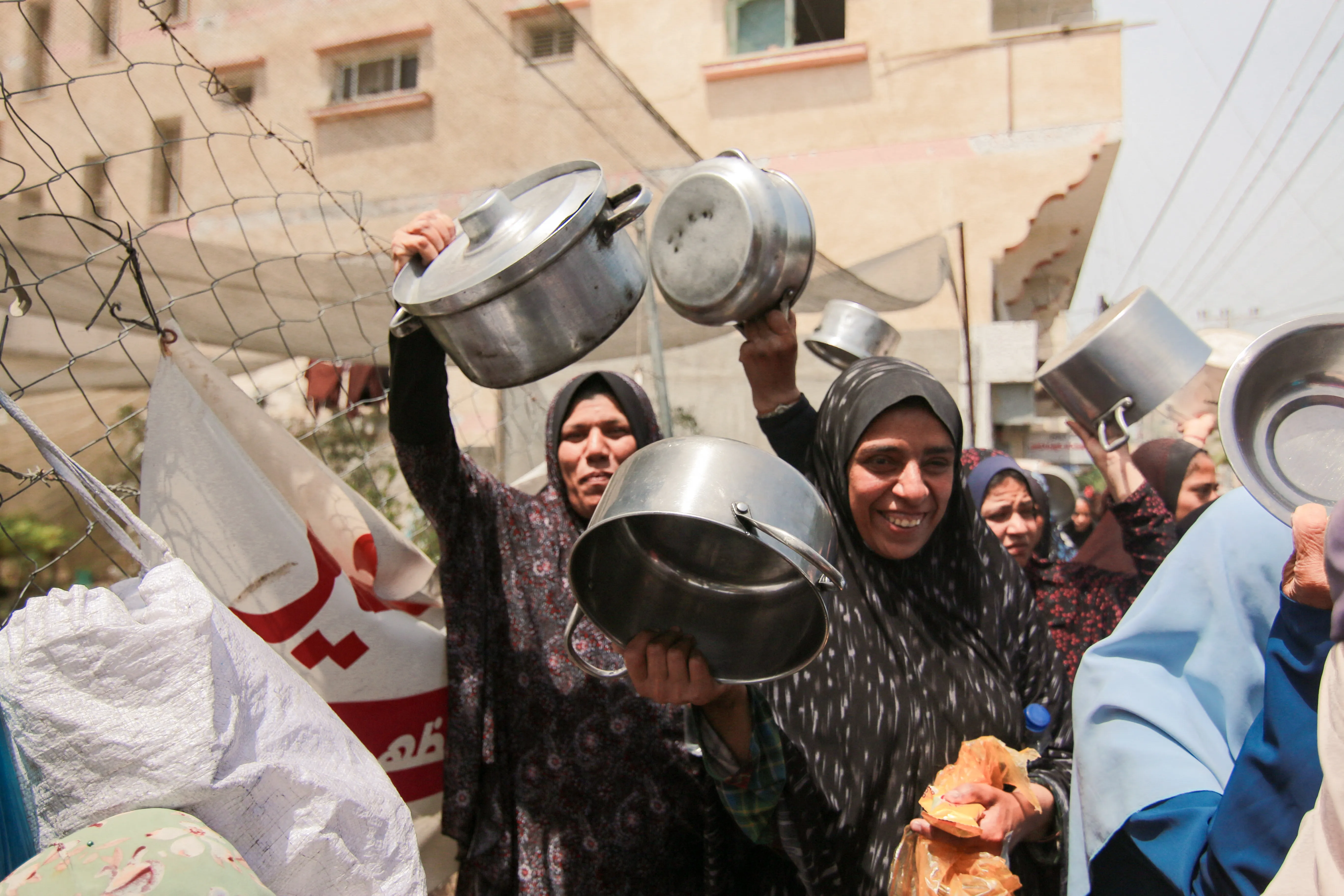 Palestinians carry empty pots during a demonstration held by the displaced Palestinians gathered in a protest carrying empty pots and pans asking for more relief aid and fuel to reach Gaza strip in Deir al-Balah, central Gaza, on Thursday, April 25, 2024.?w=200&h=150