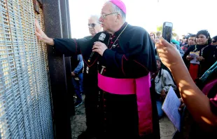 Robert W. McElroy, Archbishop of San Diego speaks with participants through the fence during the 23rd Posada Sin Fronteras where worshipers gather on both sides of the US-Mexican border fence for a Christmas celebration, at Friendship Park and Playas de Tijuana in San Ysidro, California on December 10, 2016. Sandy Huffaker/AFP via Getty Images.