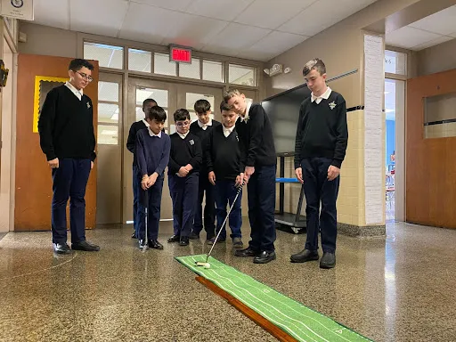 A group of third- to eighth-grade boys at St. Michael’s School in Fall River, Massachusetts, takes part in a putting competition in their after-school Young Men’s Club in 2023.?w=200&h=150