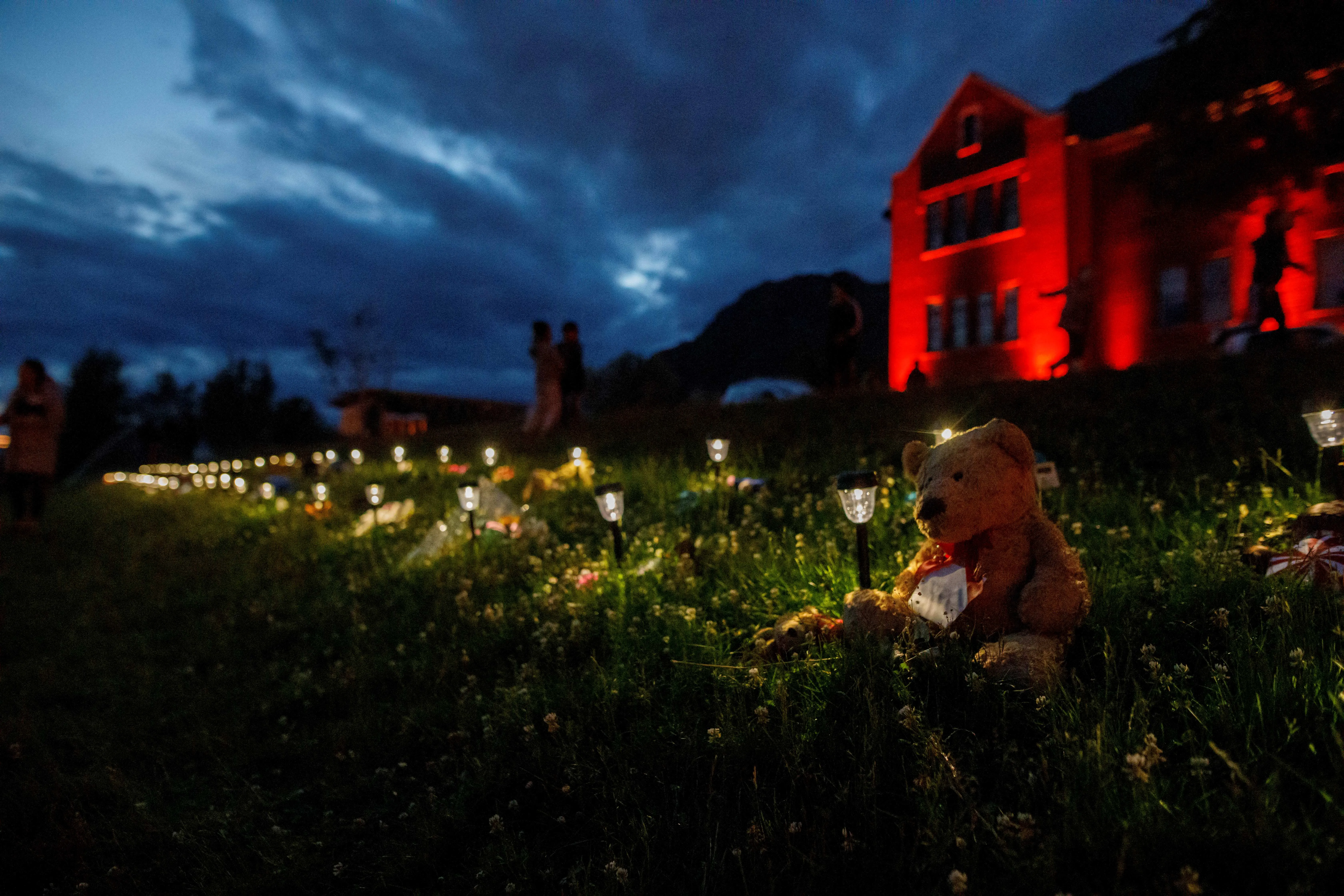A teddy bear sits beside a lantern outside the former Kamloops Indian Residential School where flowers and cards have been left as part of a growing makeshift memorial created in response to media reports that the "remains" of 215 children have been discovered buried near the facility in Kamloops on June 5, 2021.?w=200&h=150