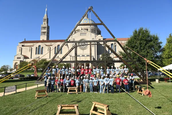 A group of students and volunteers pose in front of a latticework replica of Notre Dame de Paris at the Catholic University of America in Washington, DC, September 26, 2022. Patrick G. Ryan