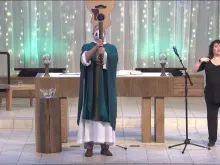 Father Terrence M. Keehan, pastor of Holy Family Catholic Church in Inverness, Illinois, using a guitar to give the final blessing at a Mass livestreamed on Feb. 13, 2022.