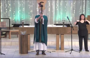 Father Terrence M. Keehan, pastor of Holy Family Catholic Church in Inverness, Illinois, using a guitar to give the final blessing at a Mass livestreamed on Feb. 13, 2022. Screenshot of YouTube video