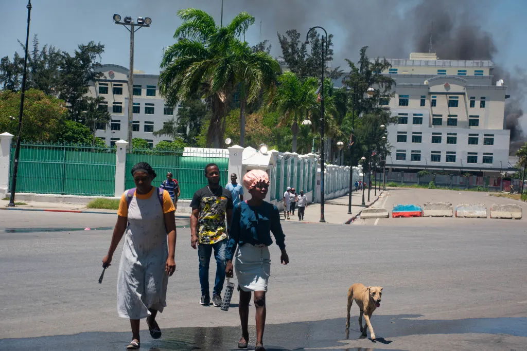 As smoke billows from the Ministry of Finance building behind them, people leave the area after hearing gunshots from armed gangs near the National Palace in Port-au-Prince, Haiti, on April 2, 2024.?w=200&h=150