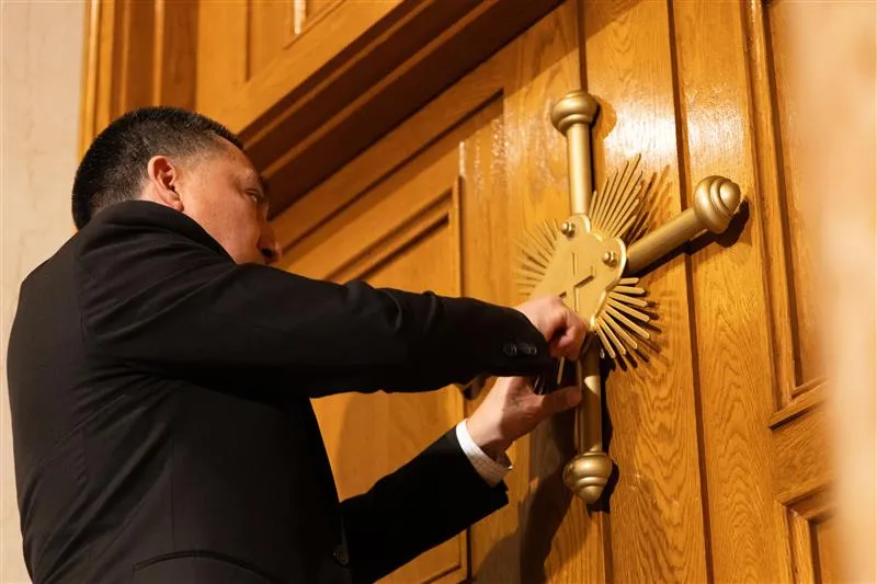 A member of the maintenance crew at the Basilica of the National Shrine of the Immaculate Conception in Washington, D.C., places a seal on the Holy Door at the basilica after Archbishop Timothy Broglio blessed the seal and doors on Dec. 3, 2023.?w=200&h=150