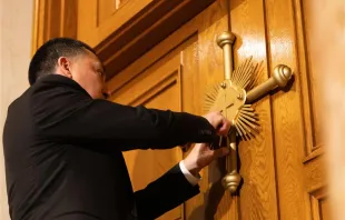 A member of the maintenance crew at the Basilica of the National Shrine of the Immaculate Conception in Washington, D.C., places a seal on the Holy Door at the basilica after Archbishop Timothy Broglio blessed the seal and doors on Dec. 3, 2023. Credit: The Basilica of the National Shrine of the Immaculate Conception