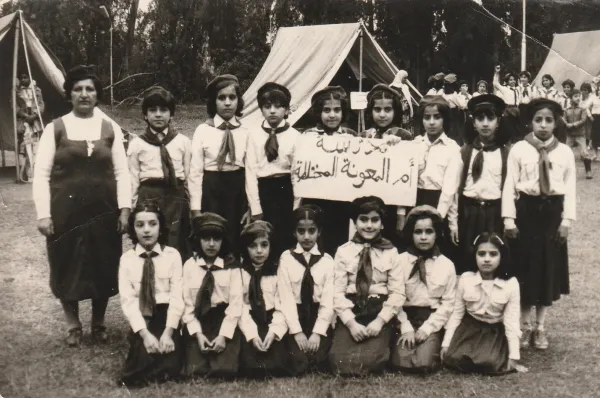 Georgena Habbaba prikazana oko 1985. naprijed kako kleči, treća slijeva, sa svojim školskim izviđačkim timom u kaldejskoj katoličkoj školi Naše Gospe od Neprestane Pomoći u Mosulu, Irak.  Habbaba, koja sada živi u Sjedinjenim Državama, rekla je da su njezina sjećanja na dane djetinjstva u školi i župi 