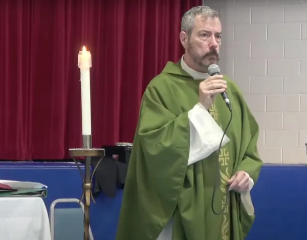 Father Samuel Giese, pastor of St. Jane Frances de Chantal Catholic Parish in Bethesda, Maryland, speaks during a live-streamed Sunday Mass in the parish school's gymnasium on July 10, 2022, hours after his church was vandalized and set on fire. Screenshot from YouTube video
